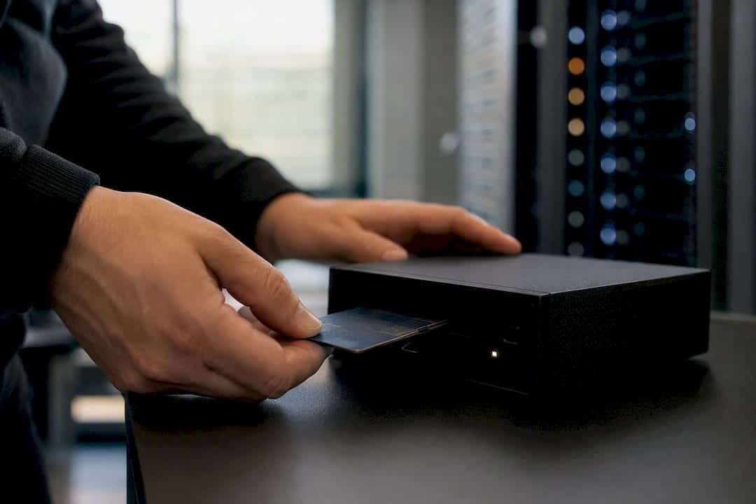 Une personne insère une carte d’accès physique dans un lecteur de données.