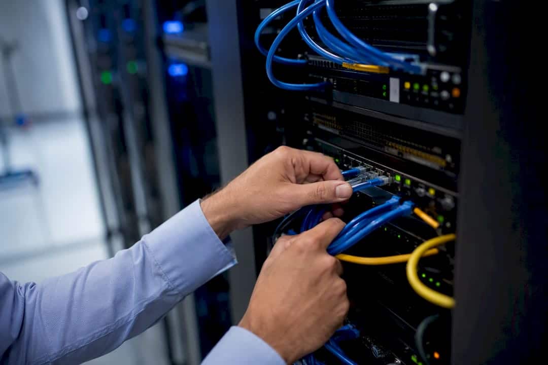 Concepts de data analytics : le guide pratique pour décideurs 1 Des mains branchent des câbles sur une baie de serveurs dans un centre de données.
